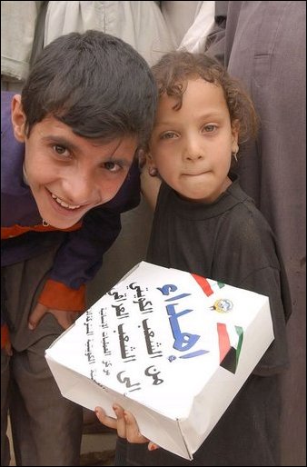 Iraqi children show humanitarian food rations distributed by citizens of Kuwait and U.S. Army soldiers during an effort to distribute food and water to Iraqi citizens in need.