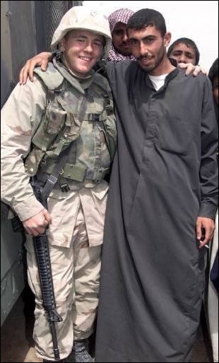 Lance Corporal Robert Wood a driver with MWSS-271 stands with an Iraqi farm boy during a humanitarian visit in support of Operation Iraqi Freedom on April 8, 2003. The village is located near Three Rivers in Iraq. (Official USMC photo by LCpl. Alicia M. Anderson) 