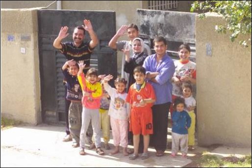 An Iraqi family waves to the Marines of Charlie Company 1st Tank Battalion along Highway 6, April 14, 2003. 