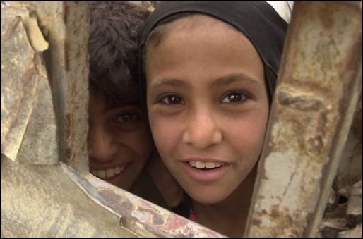 A little girl of An Najaf, Iraq, watches through a gate while U.S. Army soldiers of 3rd Platoon, A. Company, 1st Battalion, 327th Infantry Regiment, patrol through her neighborhood on April 19, 2003. During patrols assessments are conducted and recorded that will help improve the quality of life for the citizens; patrols also deter the enemy. The 101st Airborne (Air Assault) Division deployed in support of Operation Iraqi Freedom. Operation Iraqi Freedom is the multinational coalition effort to liberate the Iraqi people, eliminate Iraq's weapons of mass destruction and end the regime of Saddam Hussein. (U.S. Army photo by Sgt. Kyran V. Adams.)