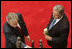 With President Oscar Berger looking on, President George W. Bush lays a white rose in the palm of the Peace Monument, symbolizing 24 hours of peace, during arrival ceremonies Monday, March 12, 2007, at the National Palace of Culture in Guatemala City. White House photo by Paul Morse