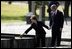 President George W. Bush and Mrs. Bush place a rose at the end of the railroad tracks at the Birkenau concentration camp in Poland, Saturday, May 31, 2003. White House photo by Paul Morse