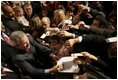 President George W. Bush autographs mementos after participating in a discussion on strengthening Social Security in Little Rock, Ark., Friday, Feb. 4, 2005.