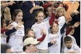 Wearing matching of T-shirts, a group of future retirees wave during the President's visit to Shreveport, La., Friday, March 11, 2005.