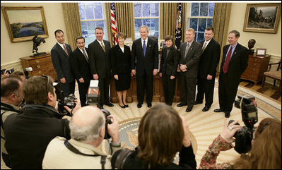 President George W. Bush and the crew members of the Space Shuttle Discovery (STS-114) pose for news photographers in the Oval Office at the White House, Wednesday, Feb. 22, 2006. The STS-114 crew was the first U.S. Space Shuttle flight, July 26, 2005, since the February 2003 loss of the Space Shuttle Columbia.