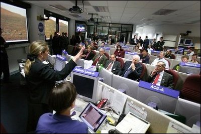 Vice President Dick Cheney listens to a briefing on NASA's Spirit and Opportunity Expeditions to Mars in the Jet Propulsion Laboratory's mission control room in Pasadena, Calif., Jan. 14, 2004. JPL developed and now remotely controls the rover Spirit since it landed on the planet Jan. 3, 2004. Sitting next to Vice President Cheney are, from left, Dr. Frederick D. Gregory, NASA Deputy Administrator, Dr. David Baltimore, President of the California Institute of Technology and Dr. Charles Elachi, the Director of the Jet Propulsion Laboratory.