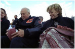 Vice President Dick Cheney signs a football for a Natrona County High School student while watching the school's homecoming game with his high school sweetheart, Lynne Cheney, in Casper, Wyo., Sept. 20, 2002. 