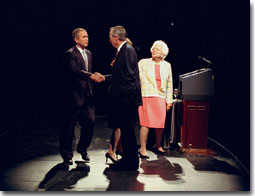 President George W. Bush shakes hands with his father, former president George Bush, as former first lady Barbara Bush looks on from the podium during a Celebration of Reading event Thursday, April 26, in Houston. WHITE HOUSE PHOTO BY PAUL MORSE