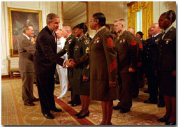 President George W. Bush and Secretary of Defense Donald H. Rumsfeld congratulate re-enlistees at the White House Wednesday, May 23. WHITE HOUSE PHOTO BY ERIC DRAPER