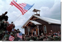 President George W. Bush and Laura Bush walk out of the chapel at Camp Bondsteel and are greeted by troops July 24, 2001 in Kosovo, Federal Republic of Yugoslavia.  White House photo by Eric Draper