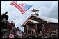 President George W. Bush and Laura Bush walk out of the chapel at Camp Bondsteel and are greeted by troops July 24, 2001 in Kosovo, Federal Republic of Yugoslavia. White House photo by Eric Draper.