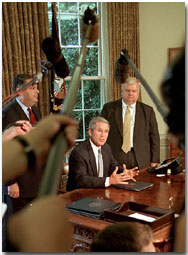 President Bush, Secretary of Energy Spencer Abraham (left) and economic advisor Larry Lindsey speak with the media in the Oval Office before the President signed an executive order that sets a standard of energy efficiency July 31, 2001. 