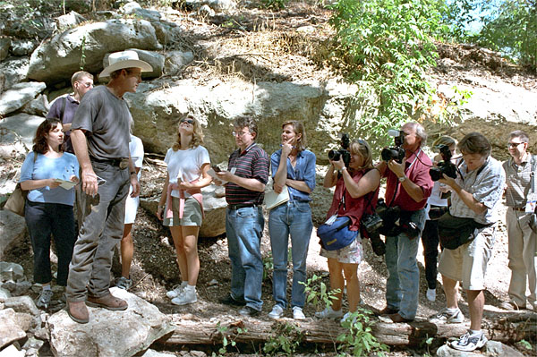 It may not be a show down at high noon, but a few good-natured shots are fired as President Bush gives the press pool a tour of his ranch at Crawford, Texas, Aug. 25. White House photo by Moreen Ishikawa.