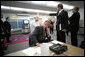 As Director of Communications Dan Bartlett points to news footage of the World Trade Center Towers burning, President George W. Bush gathers information about the attack at Emma E. Booker Elementary School in Sarasota, Fla., Sept. 11, 2001. Also photographed are Director of White House Situation Room, National Security Council, Deborah Loewer (directly behind the President) and Senior Advisor Karl Rove (right). White House photo by Eric Draper