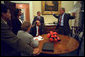 Returning from Sarasota, Fla., where he first saw news footage of the attack, President George W. Bush immediately gathers his senior staff in the private dining room off the Oval Office Sept. 11, 2001. Meeting with the President from left to right are White House Counsel Alberto Gonzales, Counselor Karen Hughes, National Security Advisor Dr. Condoleezza Rice, Press Secretary Ari Fleischer and Chief of Staff Andy Card. White House photo by Eric Draper