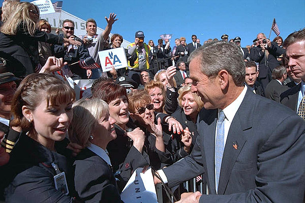 Greeted by a roaring crowd of good cheer, President Bush visits with Arline employees at Chicago's O'Hare International Airport Sept. 27. "And one of the great goals of this nation's war is to restore public confidence in the airline industry," said the President explaining that his staff flew on commercial airplanes for the Midwest meeting. White House photo by Eric Draper.