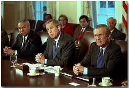 With Secretary of State Colin Powell and Secretary of Defense Donald Rumsfeld sitting at his side, President George W. Bush speaks with the media during a cabinet meeting Nov. 19. White House photo by Tina Hager.