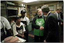 Visiting the kitchen of So Others Might Eat charity, President George. W. Bush greets director Father Adams and other volunteers at the Washington D. C. site Nov. 20. Started in 1970, the program serves breakfast and lunch daily to homeless. White House photo by Tina Hager.