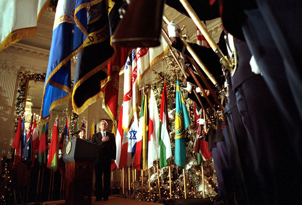 As they lay their hands over their hearts, President George W. Bush and Mrs. Laura Bush listen to the playing of the National Anthem during The World Will Always Remember September 11th Ceremony in the East Room Dec. 11. "When we fight terror, we fight tyranny; and so we remember," said the President in the ceremony honoring the memories and families of those who died in the Sept. 11 attacks. White House photo by Eric Draper.