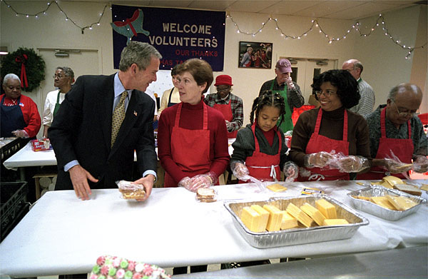 Visiting "Martha's Table" center for homeless adults and children, President George W. Bush talks with volunteer Connie Jeremiah December 20. The president helped pack sandwiches into carrying crates at the center which has been providing food to the hungry since 1980. White House photo by Eric Draper.