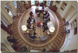 President George W. Bush hosts a meeting in the Oval Office decorated with the new presidential rug on December 20, 2001. The rug, which is unique to the Bush administration, arrived earlier in the week and was unveiled to the media on Friday December 21, 2001. Members from the Office of Homeland Security and other White House staff attended the meeting. The participants included (clockwise from the bottom), President George W. Bush, Governor Tom Ridge, Dr. Condoleezza Rice, Admiral Steve Abbot, Karen Hughes, Dean McGrath, Karl Rove, Albert Hawkins, Mitch Daniels, Josh Bolton, and Andy Card. White House Photographer Paul Morse is at left. White House photo by Paul Morse.