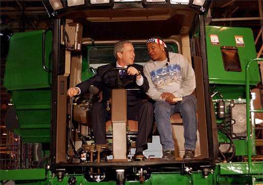 President George W. Bush talks with assembly worker Deborah Davis after starting up a combine with a gold-plated ignition key at John Deere Harvester Works in East Moline, Ill., Monday, Jan. 14, 2002. "I'm confident in the American farmer," said the President, addressing about 1500 employees and supporters. "I know the American farmer is more efficient, and can raise more crop than anybody, anywhere in the world." White House photo by Eric Draper.