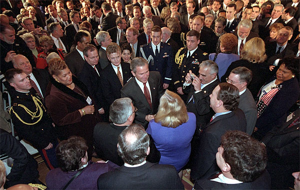 President George W. Bush wades into a crowd of handshakes and flashing cameras as he welcomes mayors and county official to the East Room Jan. 24. White House photo by Tina Hager.