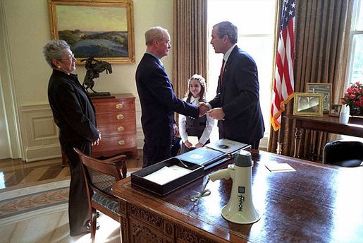 President George W. Bush welcomes retired New York firefighter Bob Beckwith and his wife Barbara to the Oval Office Feb. 25. Mr. Beckwith and New York Governor George Pataki visited the White House to present the President with the bullhorn the President used to talk with recovery workers during a visit to the World Trade Center Sept. 14, 2001.