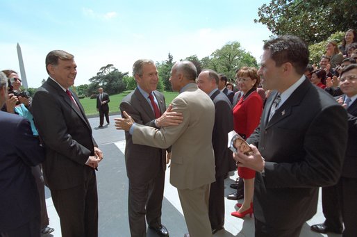 Accompanied by Secretary of Housing and Urban Development Mel Martinez (immediate left of the President), President George W. Bush meets with members of his staff on the South Lawn after posing for a group portrait with approximately 160 White House hispanic employees. White House photo by Eric Draper.