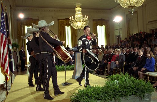 President George W. Bush and Laura Bush listen to Pedro Fernandez perform during a reception honoring Cinco de Mayo in the East Room Friday, May 3. "The victory we commemorate today is a source of tremendous pride to the people of Mexico, and a source of inspiration to the people of America," said the President in his remarks of the celebration that marks Mexico's victory over French occupying forces at the Battle of Puebla in 1862. White House photo by Susan Sterner.