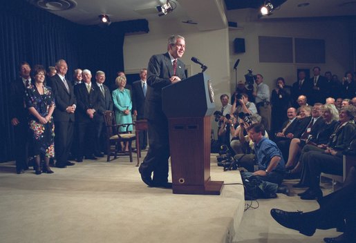 Accompanied by Congress members, President George W. Bush signs the Farm Security and Rural Investment Act of 2002 in the Dwight D. Eisenhowser Executive Office Building May 13. "This bill is generous, and will provide a safety net for farmers. And it will do so without encouraging overproduction and depressing prices. It will allow farmers and ranchers to plan and operate based on market realities, not government dictates," said the President. White House photo by Eric Draper.