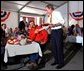 President George W. Bush greets Texas hog farmer George Fink before sitting down to eat during a barbque picnic with pork producers and their families at the World Pork Expo in Des Moines, Iowa, Friday, June 7, 2002. 