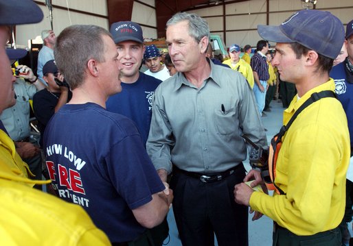 President George W. Bush greets members of the fire deparment in Show Low, Ariz., during his visit to the forest fire area in Springerville, Ariz., Tuesday, June 24. 