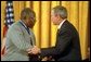 President George W. Bush presents the Presidential Medal of Freedom to baseball legend Henry Aaron during a ceremony at the White House, July 9, 2002. "The Presidential Medal of Freedom is the highest civil honor our nation can bestow. And we award it today to 12 outstanding individuals," said the President. "The men and women we honor span the spectrum of achievement. Some are fighters; others are healers; all have left an enduring legacy of hope and courage and achievement." White House photo by Eric Draper.