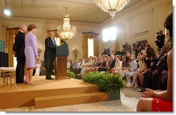 President George W. Bush watches the new Public Service Announcement that encourage adoption with Actor Bruce Willis and Mrs. Bush in the East Room July 23, 2002. White House photo by Tina Hager.