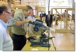 President George W. Bush takes a turn at a table saw during a Labor Day tour of the Carpenters Joint Apprenticeship Center on Neville Island, Pennsylvania. White House photo by Paul Morse.