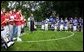 President George W. Bush listens to the National Anthem with T-Ball teams East Brunswick New Jersey Babe Ruth Buddy Ball League Sluggers in red and the Waynesboro Little League Challenger Division Sand Gnats in blue from Waynesboro, Virginia Sunday September 22, 2002 on the South Lawn of the White House. White House photo by Paul Morse.