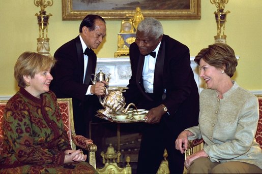 Ludmila Putina, wife of Russian Federation President Vladimir Putin, and Laura Bush are served coffee by White House Butlers Ricardo San Victores and James Ramsey in the Yellow Oval Room following the opening ceremonies for the Second Annual National Book Festival. Mrs. Bush invited Mrs. Putin to the Book Festival following a visit to a children's library in Moscow last Spring. Mrs. Putin is interested in hosting a book festival in Russia. White House photo by Susan Sterner.