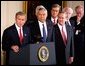 Accompanied by a bipartisan group of legislators, President George W. Bush signs H.J. Resolution 114 authorizing the use of force against Iraq in the East Room Wednesday, Oct. 16. "The resolution I'm about to sign symbolizes the united purpose of our nation, expresses the considered judgment of the Congress, and marks an important event in the life of America," said President Bush. Standing next to the President are Secretary of State Colin Powell, center, and Secretary of Defense Donald Rumsfeld, right. White House photo by Paul Morse.