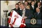 Receiving a jersey from team captain Steve Yzerman, President George W. Bush welcomes the Detroit Red Wings, winners of the NHL 2002 Stanley Cup Championship, to the East Room of the White House Friday, Nov. 8. White House photo by Paul Morse.