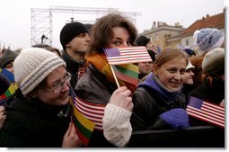 Waiting for President Bush and President Adamkus, a crowd member plays with the American and Lithuanian flag at the Rotuse Square in Vilnius, Lithuania, Nov. 23. "You (the Lithuanian people) have known cruel oppression and withstood it. You were held captive by an empire and you outlived it. And because you have paid its cost you know the value of human freedom," said President Bush in his remarks. "Lithuania today is true to its best traditions of democracy and tolerance and religious liberty, and you have earned the respect of my nation and all nations."  White House photo by Paul Morse