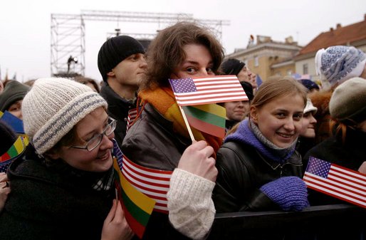 Waiting for President Bush and President Adamkus, a crowd member plays with the American and Lithuanian flag at the Rotuse Square in Vilnius, Lithuania, Nov. 23. "You (the Lithuanian people) have known cruel oppression and withstood it. You were held captive by an empire and you outlived it. And because you have paid its cost you know the value of human freedom," said President Bush in his remarks. "Lithuania today is true to its best traditions of democracy and tolerance and religious liberty, and you have earned the respect of my nation and all nations." White House photo by Paul Morse