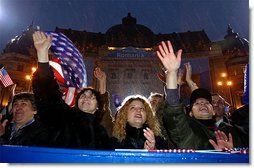 Braving a cold rain, thousands of Romanian citizens came to Revolution Square to hear President Bush speak Nov. 23. "I know that your hardship did not end with your oppression. America respects your labor, your patience, your daily determination to find a better life. Your effort has been recognized by an offer to NATO membership. We welcome Romania into NATO," said President Bush.  White House photo by Paul Morse