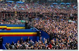 Standing with Romanian President Iliescu, President George W. Bush waves to thousands of Romanians in Revolution Square in Bucharest, Romania, Nov. 23. The square is the site of the 1989 revolt that toppled communist rule and where the Romanian people denounced the dictator Nicolae Ceausescu. "And here, in December of 1989, you broke the silence of your captivity," remarked President Bush. "From that balcony, the dictator heard your voices and faltered -- and fled. Two generations of bitter tyranny ended, and all the world witnessed the courage of Romania, the courage that set you free."  White House photo by Paul Morse