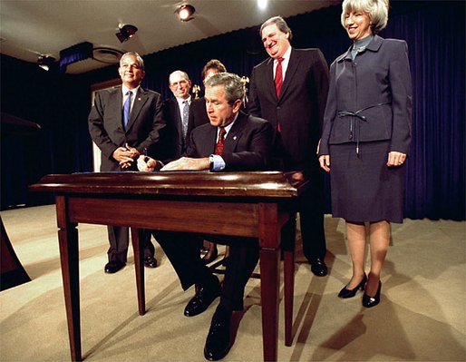 President George W. Bush signs H.R. 3908, the Reauthorization of the North American Wetlands Conservation Act in the Dwight D. Eisenhower Executive Office Building Dec. 2. Standing with the President for the signing are, from left to right, Rep. Robert Underwood (D-Guam), Rep. Wayne Gilchrest (R-MD), Sec. of Agriculture Ann Veneman, Sen. Bon Smith (R-NH) and Sec of Interior Gale Norton. The legislation matches federal funds with non-federal sources to promote public-private partnerships that conserve and restore the nation's wetlands. White House photo by Tina Hager