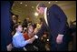 President George W. Bush talks to Solveig Haugen, her twin sister Liv and their younger brother Tad, after the signing of the Dot Kids Implementation and Efficiency Act of 2002 in the Roosevelt Room, Dec 4. The Haugen family of Loudoun County, Virginia is one family that will benefit from the act. The bill creates a second level Internet domain (kids.us), within the United States country code, that will provide a safe online environment for children ages 13 and under. White House photo by Eric Draper.