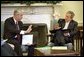 Reviewing a report about the Space Shuttle Columbia tragedy, President George W. Bush meets with NASA Administrator Sean O'Keefe in the Oval Office Monday, Feb. 3, 2003. White House photo by Eric Draper.