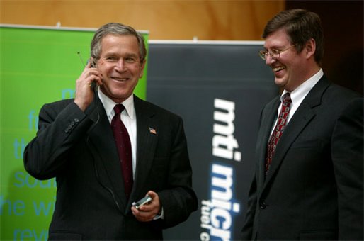 President George W. Bush tries out a cell phone powered by hydrogen fuel cell technology during a demonstration of energy technologies at The National Building Museum in Washington, D.C., Thursday, Feb. 6, 2003. Accompanied by EPA Administrator Christie Todd Whitman and Department of Energy Secretary Spencer Abraham, the President reviewed fuel cell technology in applications ranging from cars to laptop computers. White House photo by Paul Morse.