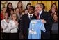 Tony Lawson, captain of the University of California, Los Angeles men's soccer team, presents President George W. Bush with a team jersey during a visit by the NCAA Fall Champions in the East Room Monday, Feb. 24, 2003. White House photo by Tina Hager