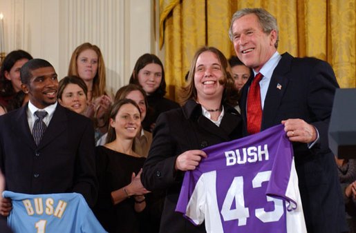 Valerie Fletcher, captain of the women's soccer team at University of Portland, gives President George W. Bush a team jersey during a visit by the NCAA Fall Champions in the East Room Monday, Feb. 24, 2003. White House photo by Tina Hager